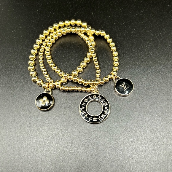3 LV zipper pull charms on a 3 set gold color stretchable brac… - Picture 2 of 5